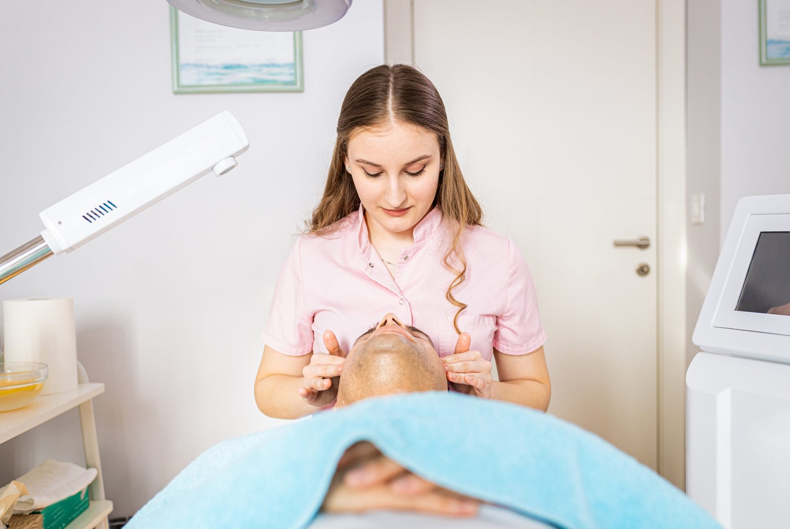Beautician doing face treatment in beauty salon to a man.
